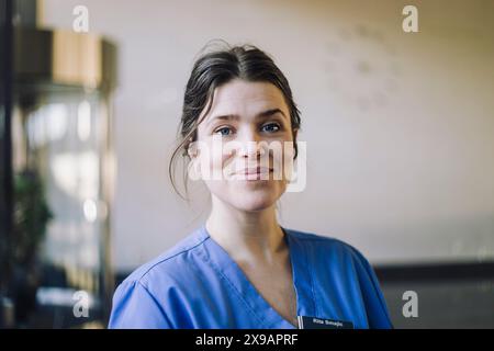 Ritratto di medico donna sorridente in scrub blu in ospedale Foto Stock