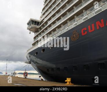 La nuova nave da crociera di Cunard "Queen Anne" ormeggiata a Invergordon mercoledì 29 maggio 2024 con piattaforme petrolifere ormeggiate nel Cromarty Firth oltre di lei. Foto Stock