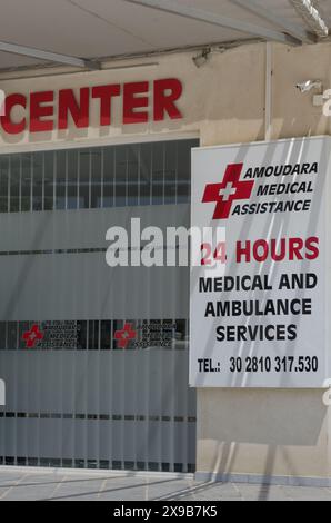 Creta, Amoudara, Grecia - 07 luglio 2018: L'ingresso al centro medico è aperto 24 ore su 24, indicando i numeri di telefono e i tipi di assistenza medica p Foto Stock