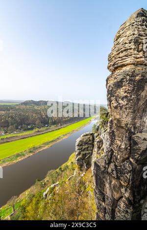 Affacciato sul tranquillo fiume Elba dall'iconica formazione rocciosa di Bastei nel Parco Nazionale della Svizzera sassone, in Germania, in una limpida giornata primaverile. Foto Stock