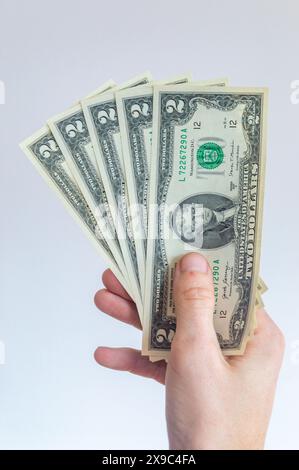 5 due dollari americani tenuti nella mano destra. Foto Stock