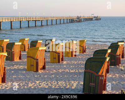 Sedie a sdraio accanto a un molo, illuminate dalla calda luce serale, atmosfera tranquilla, atmosfera autunnale sulla spiaggia di Binz con sedie a sdraio sugli alberi nel Foto Stock