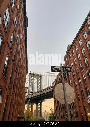 Ponte incorniciato da alti edifici in mattoni rossi con cartelli stradali chiaramente visibili, New york dall'alto con impressionanti grattacieli e nuvole nel cielo Foto Stock