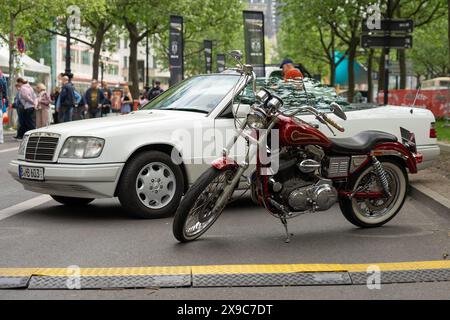 BERLINO - 4 MAGGIO 2024: La moto Harley-Davidson sullo sfondo di una Mercedes-Benz W124. Classic Days Berlin 2024. Foto Stock