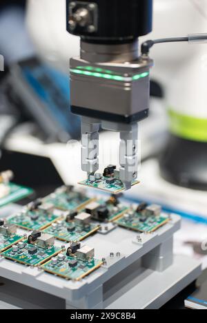 assemblaggio microchip e microprocessore con braccio robotizzato automatizzato per l'installazione di apparecchiature di fabbrica, componenti elettronici e componenti su scheda a circuito stampato Foto Stock