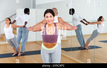 Lezioni di yoga per coppie nel moderno centro fitness Foto Stock