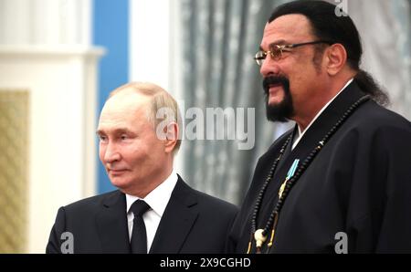 Mosca, Russia. 30 maggio 2024. Il presidente russo Vladimir Putin, a sinistra, presenta il rappresentante speciale russo per le relazioni umanitarie russo-americane, l'attore e produttore Steven Seagal, a destra, con l'ordine dell'amicizia, durante una cerimonia di premiazione nella sala Santa Caterina del Palazzo del Cremlino, 30 maggio 2024, a Mosca, Russia. Crediti: Vyacheslav Prokofyev/piscina del Cremlino/Alamy Live News Foto Stock