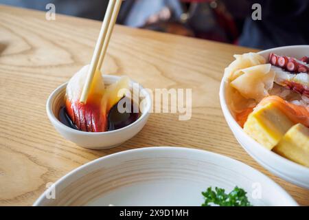 Hokkigai in bacchette, mangiare Sashimi Rice Bowl Chirashi Don cibo giapponese Foto Stock