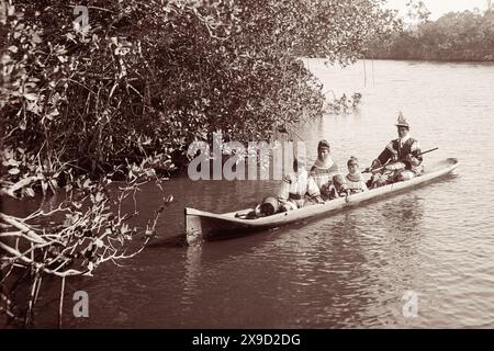 Famiglia indiana Seminole in una canoa scavata su un fiume a Miami, Florida, all'inizio degli anni '1900 (USA) Foto Stock