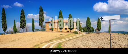 Montepulciano, Italia - 25 agosto 2013: Casa in mattoni nelle campagne della Toscana, Italia. La strada che porta alla casa. Paesaggio rurale con strada amon Foto Stock