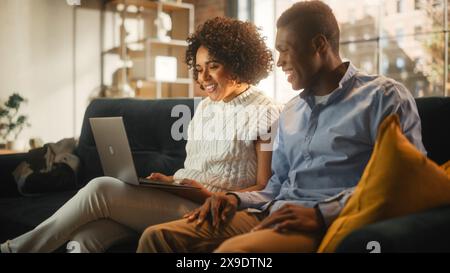 Splendida coppia autentica nell'accogliente soggiorno che effettua una videochiamata sul computer portatile di casa. Coniugi che chattano con parenti o amici stretti su Internet sui social network. Foto Stock
