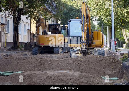 Cantiere con attrezzature di movimento terra. Riparare la carreggiata su una strada cittadina Foto Stock