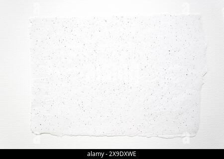 Vista dall'alto di un pezzo di carta ruvida fatta a mano su uno sfondo bianco di carta ad acquerello Foto Stock