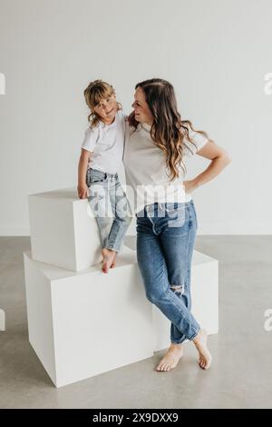 Madre e figlia indossano abiti coordinati su uno sfondo semplice Foto Stock