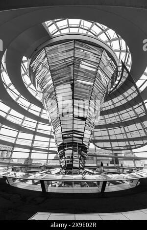 La passerella a spirale e il design moderno della cupola di vetro in cima al Berlins Reichstag Building sotto un cielo nuvoloso. La sede del Bundestag tedesco, Berlino, Germania. Immagine in bianco e nero. Foto Stock