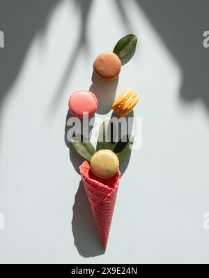 i macroni vengono inseriti in modo creativo in un cono per gelato Foto Stock