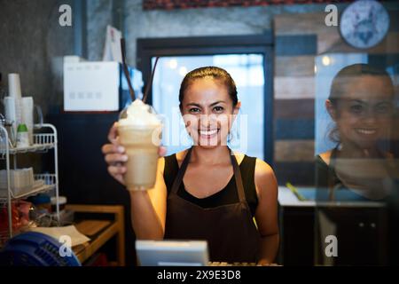 Ritratto, barista o donna felice con ordine al bar per il servizio di ospitalità al bancone della caffetteria. Bevanda con panna, sorriso o cameriera in piccolo Foto Stock