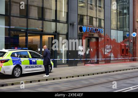 Barclays Bank, Mosley Street, centro di Manchester, Regno Unito, una porta di vetro si è rotta e coperta di vernice rossa il 31 maggio 2024. La polizia ha messo in atto un cordone. Negli ultimi mesi i manifestanti pro-Palestina hanno preso di mira questa banca e gettato vernice rossa ad altre imprese che credono stiano sostenendo Israele. Foto Stock