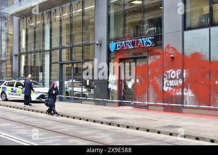 Barclays Bank, Mosley Street, centro di Manchester, Regno Unito, una porta di vetro si è rotta e coperta di vernice rossa il 31 maggio 2024. La polizia ha messo in atto un cordone. Negli ultimi mesi i manifestanti pro-Palestina hanno preso di mira questa banca e gettato vernice rossa ad altre imprese che credono stiano sostenendo Israele. I graffiti sul fronte includono: "Smettete di finanziare il genocidio”. Foto Stock