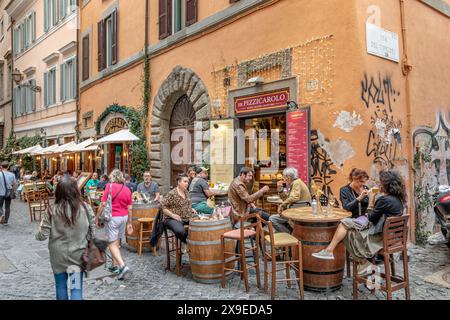 La gente sedeva fuori a mangiare in un ristorante a Trastevere, un quartiere popolare di Roma, in Italia Foto Stock