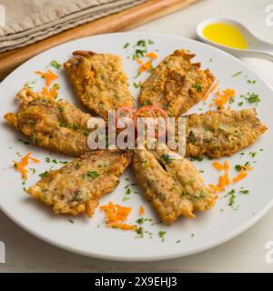 Tapa di acciughe condite con farina e uova in un ristorante spagnolo. Tapa tradizionale della gastronomia spagnola. Foto Stock