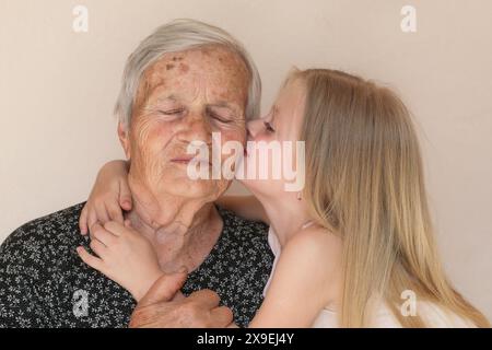 Famiglia felice, bambino e bisnonna abbracciano, rilassarsi, sorridere, amare e legare insieme, felici e contenti a casa mostrando amore e affetto Foto Stock