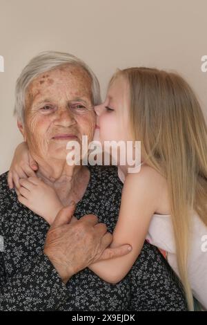 Famiglia felice, bambino e bisnonna abbracciano, rilassarsi, sorridere, amare e legare insieme, felici e contenti a casa mostrando amore e affetto Foto Stock