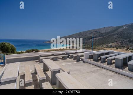 Vista delle panchine e dei tavoli presso la chiesa di Agia Theodoti che si affaccia sulla splendida spiaggia turchese di iOS Grecia Foto Stock