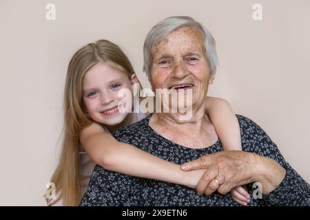 Famiglia felice, bambino e bisnonna abbracciano, rilassarsi, sorridere, amare e legare insieme, felici e contenti a casa mostrando amore e affetto Foto Stock