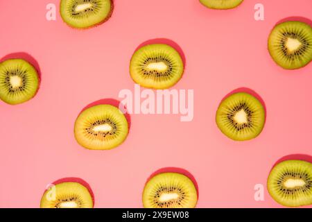 Stesa piatta di fette di kiwi su sfondo rosa Foto Stock