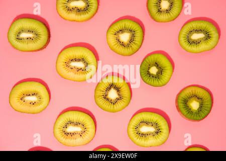 Stesa piatta di fette di kiwi su sfondo rosa Foto Stock