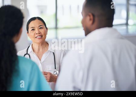 Equipe medica multietnica che discute di cura del paziente in ambiente ospedaliero Foto Stock