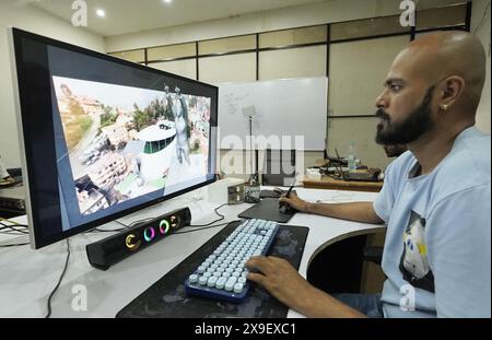 Ajmer, India. 15 maggio 2024. Divyendra Singh Jadoun, proprietaria di Polymath Synthetic Media Solutions, guarda un video che mostra il capo del governo dello stato del Sikkim, Tamang, come una statua su un edificio reale. Il video è stato creato dal suo team utilizzando l'intelligenza artificiale. Tra le altre cose, l'azienda crea video falsi per le campagne elettorali. Crediti: Himanshu Sharma/dpa/Alamy Live News Foto Stock