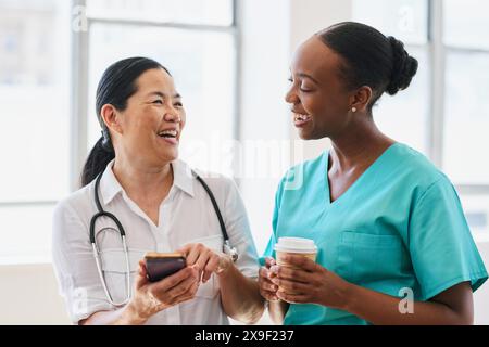 Team medico diversificato in un ambiente ospedaliero che condivide un momento di luce Foto Stock