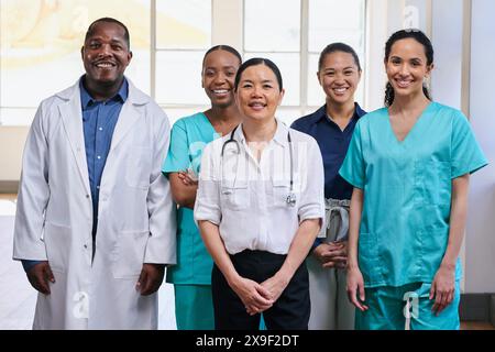 Squadra medica diversificata in piedi insieme in ospedale, sorridente Foto Stock