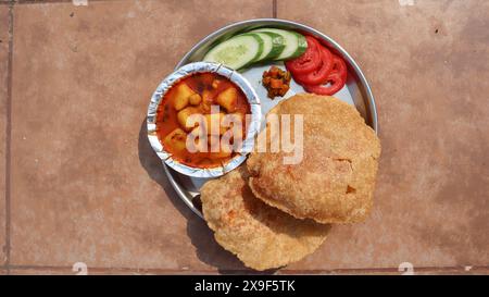 Colazione tradizionale indiana di Bedmi puri e Aloo ki sabji con insalata e sottaceti Foto Stock