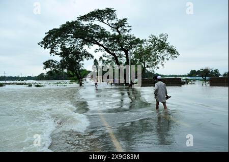 Sylhet, Bangladesh. 30 maggio 2024. Persone che lottano per attraversare la strada principale allagata della zona di Lafnaut di Goanghat upazila a causa della forte pioggia dopo che Cyclone Remal ha colpito il Bangladesh. Il 30 maggio 2024 a Sylhet, Bangladesh. (Foto di MD Rafayat Haque Khan/ Eyepix Group/Sipa USA) credito: SIPA USA/Alamy Live News Foto Stock