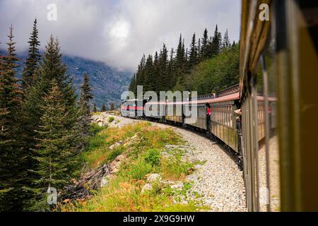 Treno a scartamento ridotto del passo bianco e del percorso Yukon sulle montagne dell'Alaska tra Skagway e il Canada Foto Stock