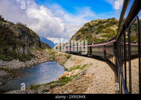 Treno a scartamento ridotto del passo bianco e del percorso Yukon sulle montagne dell'Alaska tra Skagway e il Canada Foto Stock