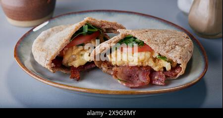 Pane Pitta ripieno di uova strapazzate, pancetta, pomodoro ed erbe aromatiche. Foto Stock