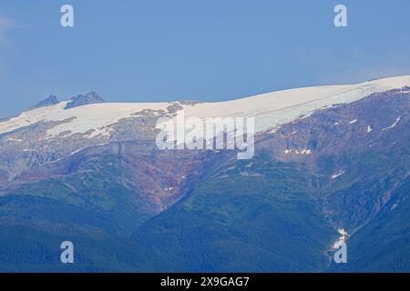 Ghiaccio fuso che scorre lungo le montagne che circondano il fiordo di Tracy Arm vicino a Juneau nel sud-est dell'Alaska, USA. Foto Stock