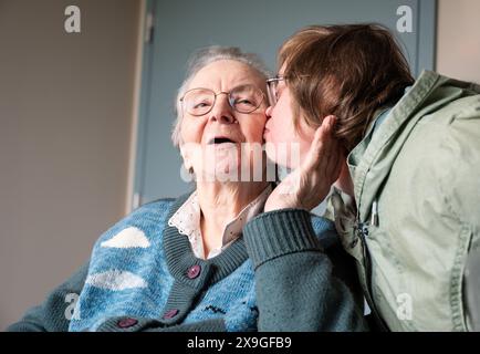 Figlia della sindrome di Down che abbraccia 85 anni madre bianca, Tienen, Fiandre, Belgio. Modello rilasciato. Foto Stock