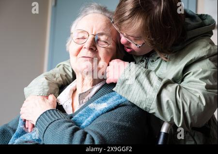 Figlia della sindrome di Down che abbraccia 85 anni madre bianca, Tienen, Fiandre, Belgio. Modello rilasciato. Foto Stock