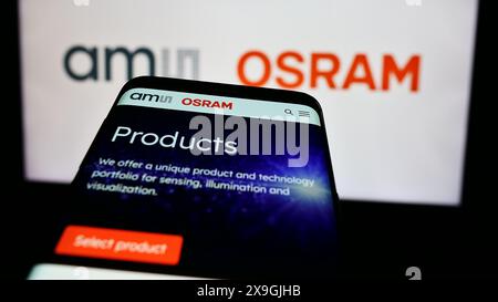 Telefono cellulare con sito web dell'azienda austriaca di elettronica ams OSRAM AG davanti al logo aziendale. Mettere a fuoco in alto a sinistra sul display del telefono. Foto Stock