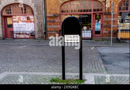 Firma in città con l'iscrizione in svedese - toilette. Segnale stradale. Ystad, Svezia - 15 maggio 2024. Foto Stock