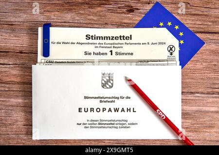 30 maggio 2024: Elezioni europee del 2024, scheda elettorale per le elezioni in Baviera per l'Europa con busta di carta per le votazioni postali su un tavolo con bandiera UE e penna a sfera da contrassegnare con il logo del partito al semaforo o del partito di governo SPD - Partito socialdemocratico di Germania *** Europawahl 2024, Stimmzettel zur Wahl in Bayern für Europa mit Stimmzettelumschlag für die Briefwahl auf einem Tisch mit EU-Fahne und Kugelschreiber zum Ankreuzen mit dem Logo der Ampel-Partei bzw. Regierungs-Partei SPD - Sozialdemokratische Partei Deutschlands Foto Stock