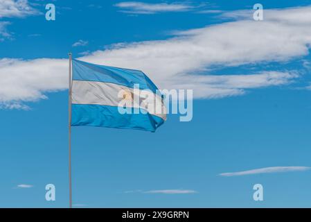 Una bandiera argentina blu e bianca con un sole giallo siede su un palo Foto Stock