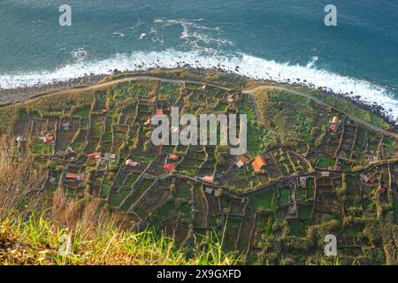 Vista aerea della costa occidentale dell'isola di Madeira (Portogallo) ad Achadas da Cruz, dove sono costruiti ricci lungo la costa in fondo a un cli Foto Stock