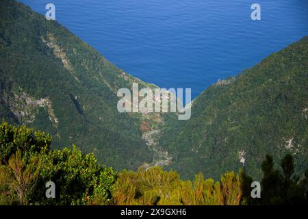 Piccolo insediamento costiero nel nord dell'isola di Madeira, parte del comune di Seixal, visto dalla foresta di Fanal laurel, una parte degli indigeni Foto Stock