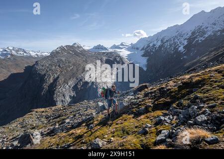 Alpinisti su un sentiero escursionistico, sentiero escursionistico a Ramolhaus, dietro le cime glaciali delle montagne e il ghiacciaio Gurgler Ferner, in autunno, vicino a Obergurgl Foto Stock
